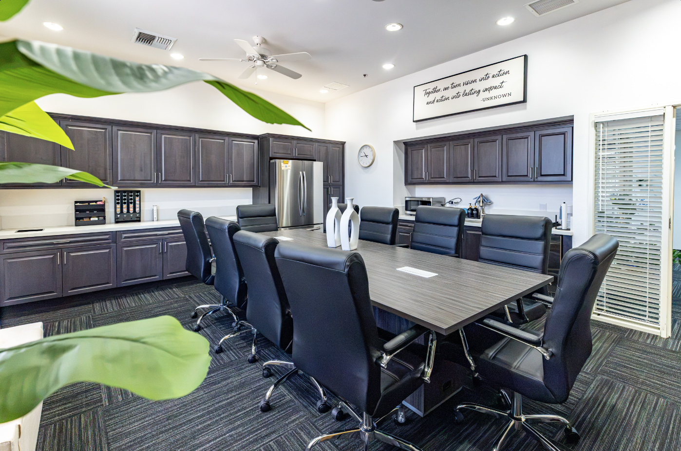 Modern conference room with large table and black chairs.