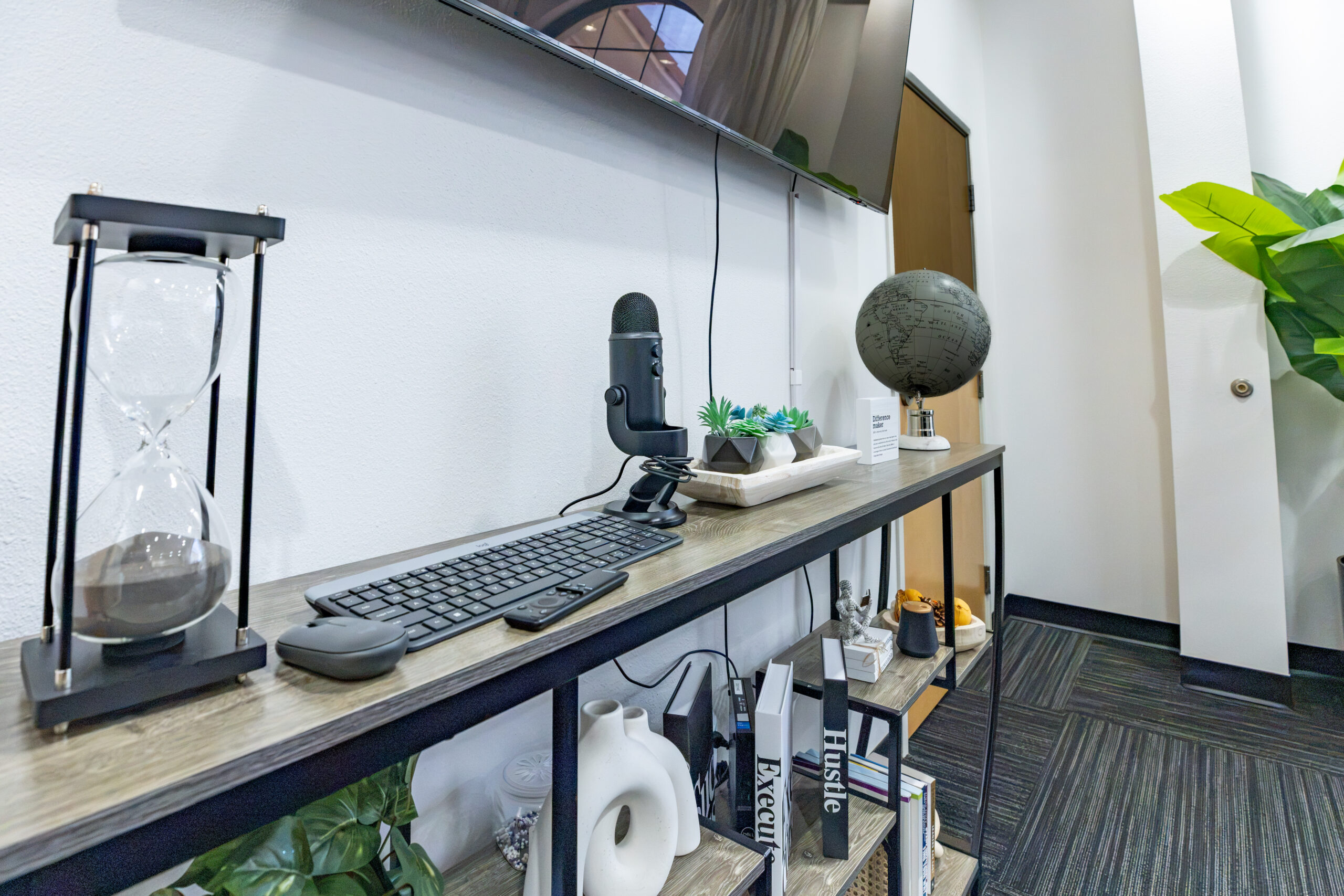Modern office workspace with desk, computer, and decorative items.