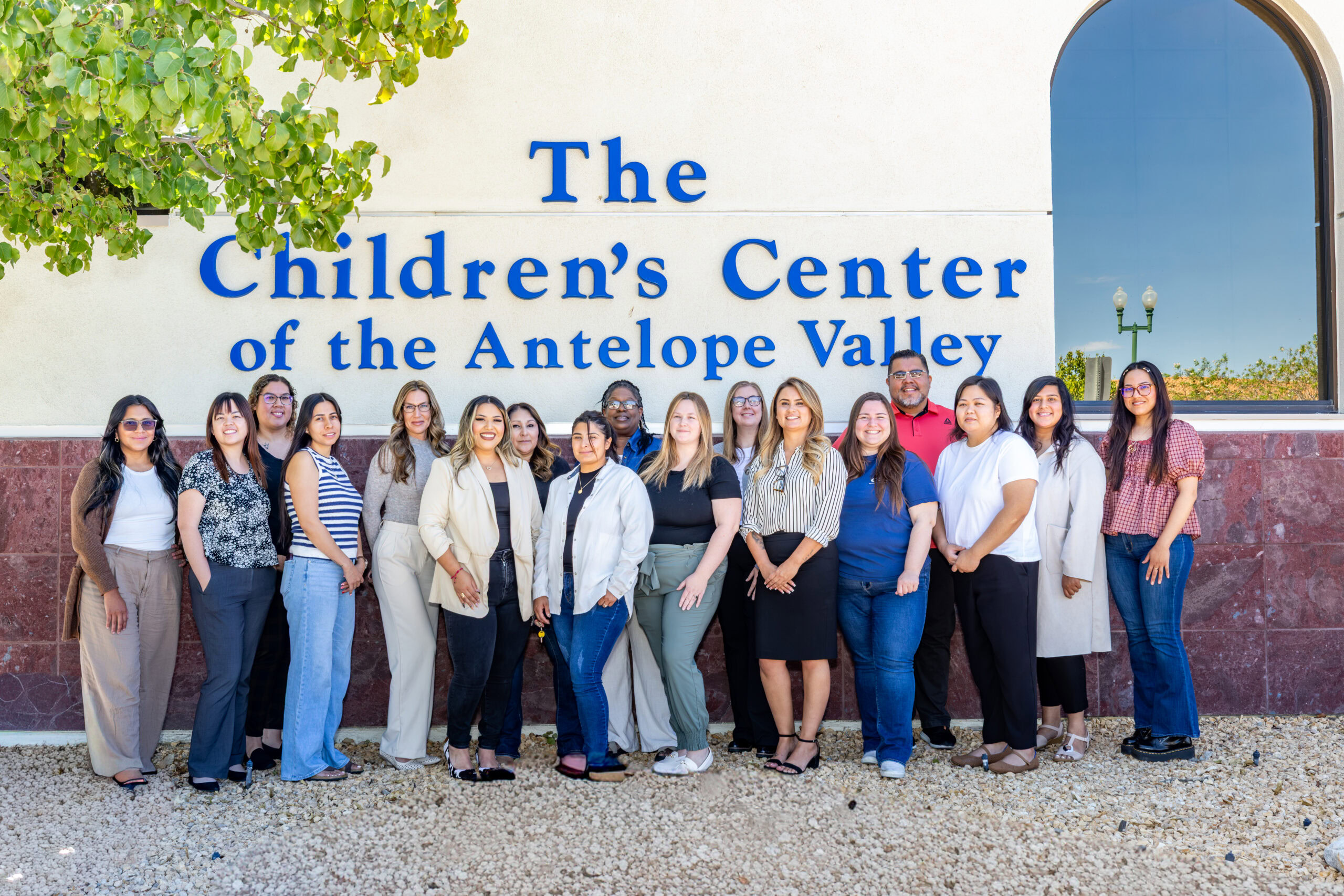 Group of diverse staff members outside The Children's Center in Lancaster.